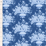 Blue floral fabric featuring ornate vases filled with abundant flowers, delicate birds and decorative details in layered shades of blue, cream and soft grey on a deep denim background.