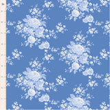 Blue floral fabric featuring trailing roses, petite blossoms and delicate leafy sprigs in cream and layered blue tones on a soft blue background.