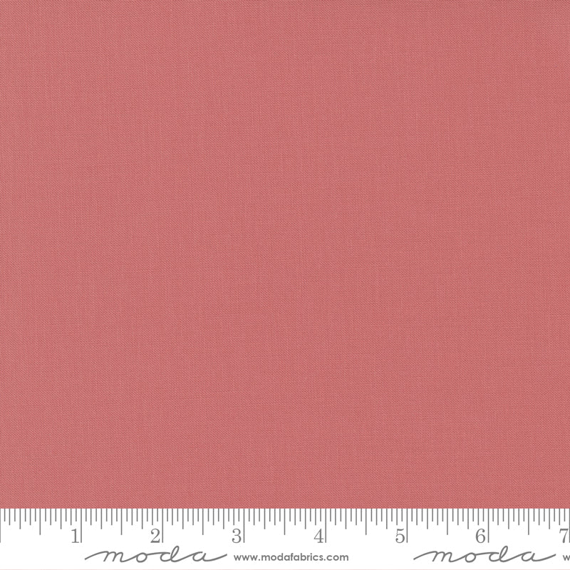 Coral Rose Bella Solid from Moda Fabrics is a warm, coral-pink solid cotton with a soft, rosy tone.