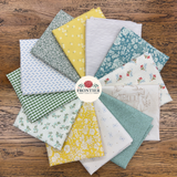 A circular arrangement of multiple fat quarters in various patterns including florals, stripes, gingham, and dots in yellow, green, blue, white, and beige, displayed on a rustic wooden background with a central 'Frontier Fabrics' logo.