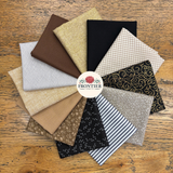 A circular arrangement of twelve different fat quarters in various patterns and colours, including stripes, florals, gingham, and metallic textures, displayed on a rustic wooden background with a central 'Frontier Fabrics' logo.