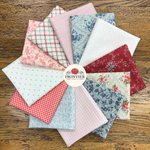 A circular arrangement of multiple fat quarters in assorted patterns and colours, including florals, stripes, gingham, and plaid, displayed on a wooden surface with a central label reading Frontier Fabrics.