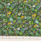 Small dense floral on cotton lawn with leafy, lime and aqua on a black background with golden yellow scattered throughout