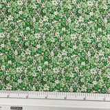 Japanese lawn fabric with a dense small-scale floral print in fresh green, sage and cream, featuring tiny flowers and leafy botanical details.