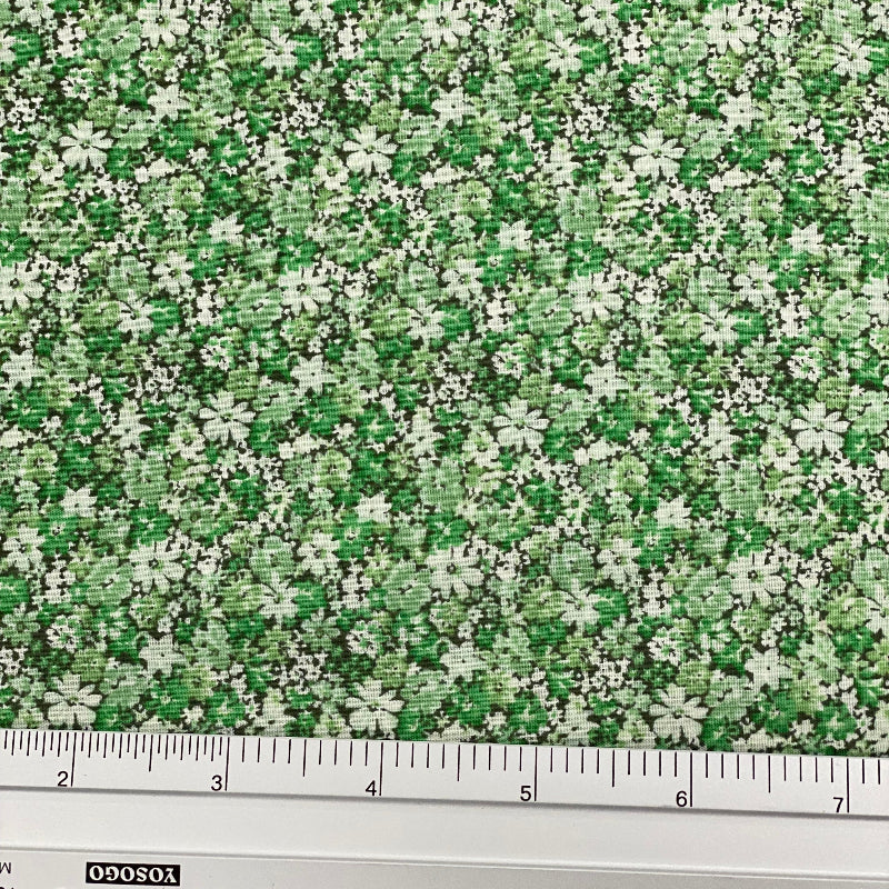 Japanese lawn fabric with a dense small-scale floral print in fresh green, sage and cream, featuring tiny flowers and leafy botanical details.