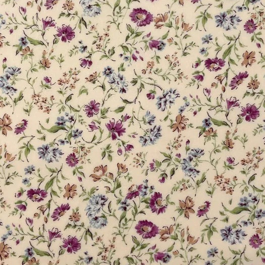 A pretty floral print from Sevenberry, featuring scattered cornflower-style blooms in soft blue, mauve, plum purple, and warm beige tones on a gentle cream background. Fine green stems and delicate leafy sprigs trail throughout the design, creating a light, graceful garden feel.

This fabric has a classic cottage floral style with a soft vintage charm, making it ideal for quilting, patchwork, dressmaking accents, linings, accessories, and romantic handmade projects.