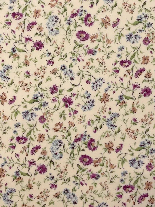A pretty floral print from Sevenberry, featuring scattered cornflower-style blooms in soft blue, mauve, plum purple, and warm beige tones on a gentle cream background. Fine green stems and delicate leafy sprigs trail throughout the design, creating a light, graceful garden feel.

This fabric has a classic cottage floral style with a soft vintage charm, making it ideal for quilting, patchwork, dressmaking accents, linings, accessories, and romantic handmade projects.