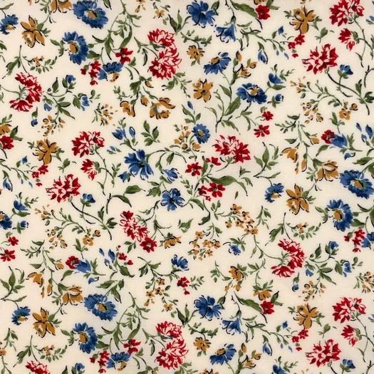 A charming floral print from Sevenberry, featuring scattered blue, red, and warm golden-brown flowers on a soft cream background. Fine green stems and leafy sprigs trail lightly across the fabric, giving the design a graceful, garden-inspired feel.

With its classic cottage-style colouring and pretty all-over floral layout, this fabric is ideal for quilting, patchwork, dressmaking accents, linings, craft projects, and vintage-inspired sewing.