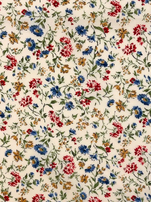A charming floral print from Sevenberry, featuring scattered blue, red, and warm golden-brown flowers on a soft cream background. Fine green stems and leafy sprigs trail lightly across the fabric, giving the design a graceful, garden-inspired feel.

With its classic cottage-style colouring and pretty all-over floral layout, this fabric is ideal for quilting, patchwork, dressmaking accents, linings, craft projects, and vintage-inspired sewing.